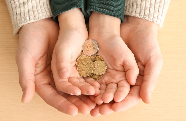Hands of man and his son holding coins