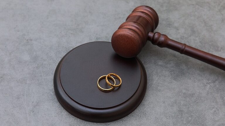 Judge gavel wedding rings on concrete stone